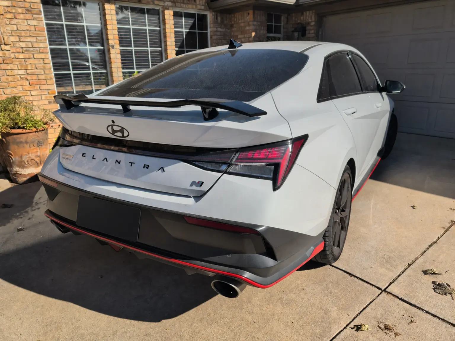 Rear details: N badging, spoiler, exhaust, rear diffuser; license plate redacted