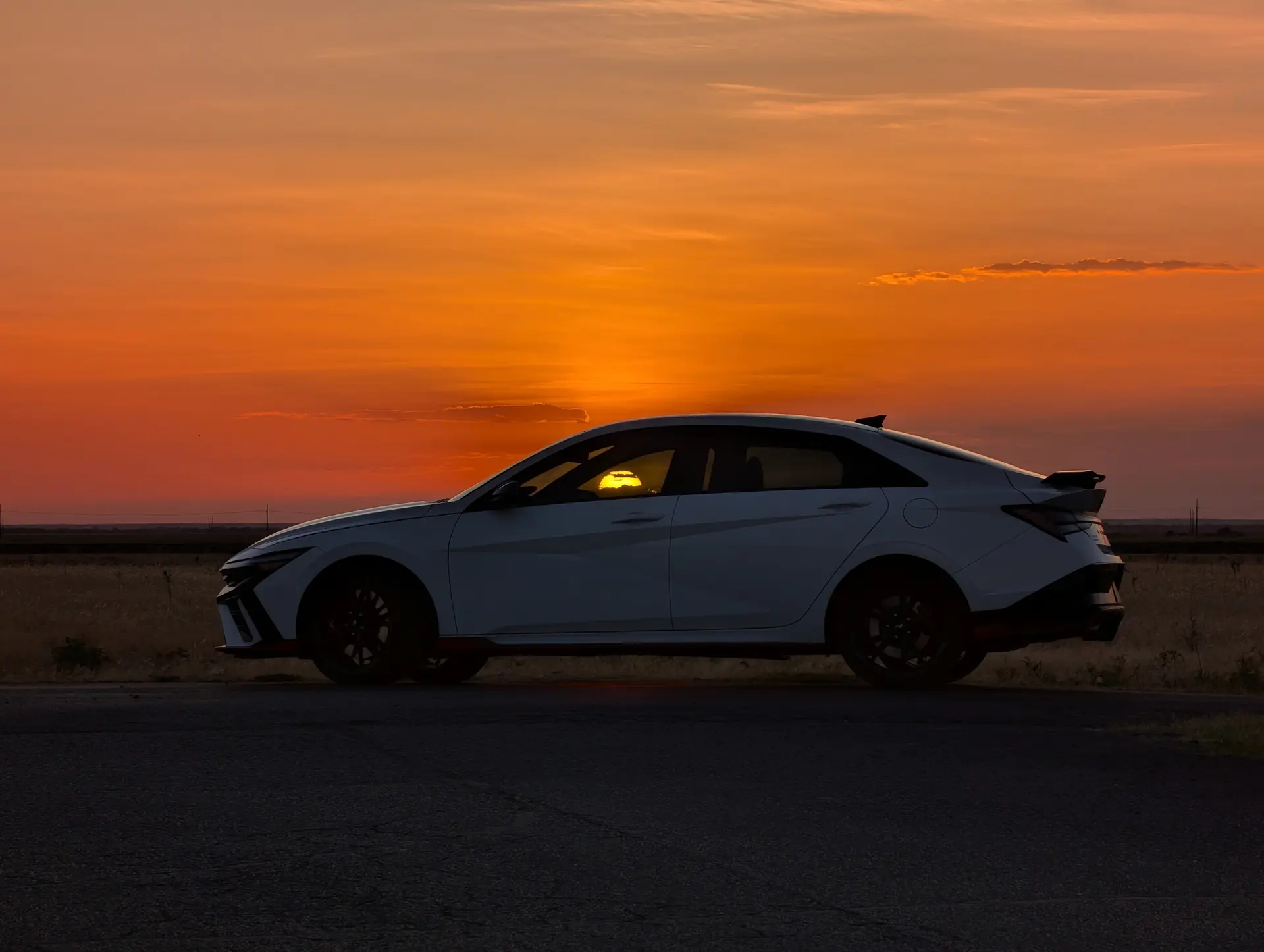 Driver-side profile with the sunset reflected through the cabin